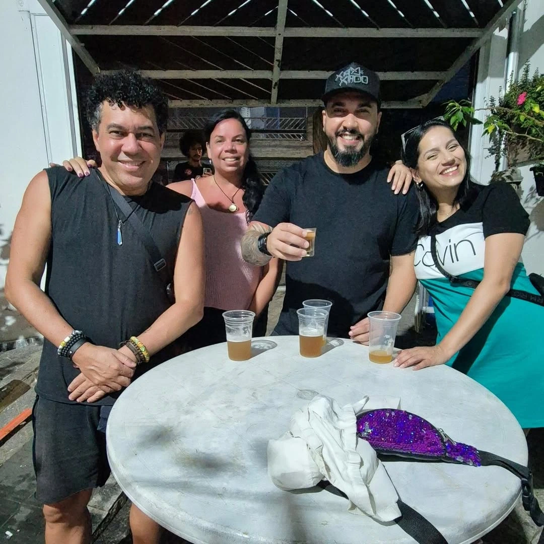 Amigos reunidos ao redor de uma mesa no Quintal da Carolina.