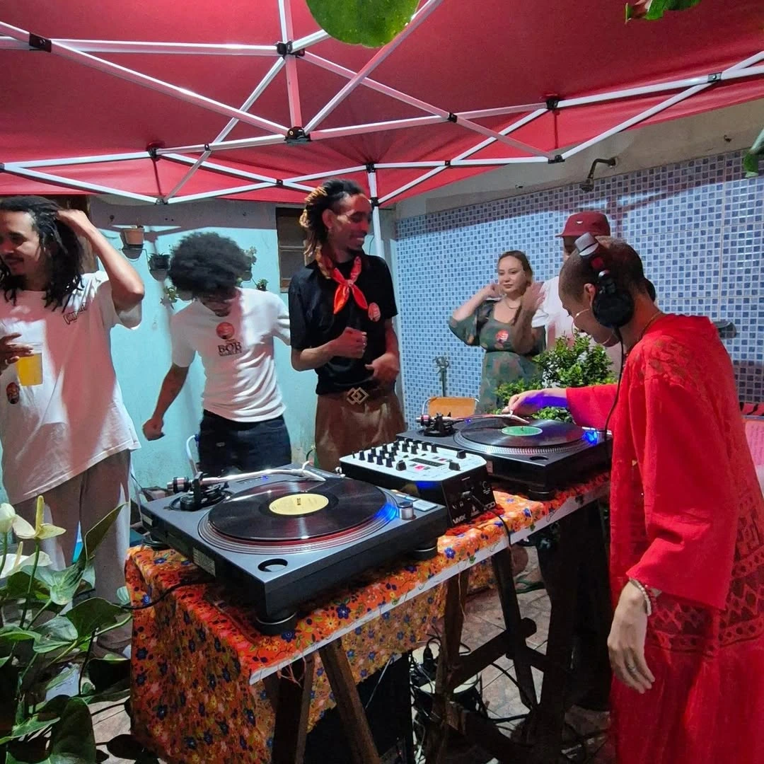 Bancada com dois toca-discos, discos e cerveja no Quintal.